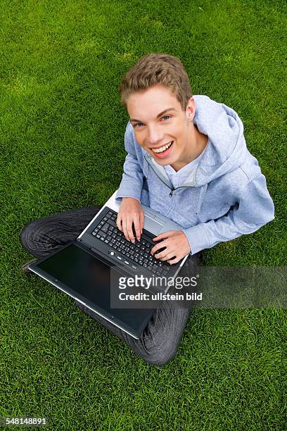 Young man with laptop on a meadow - 2010