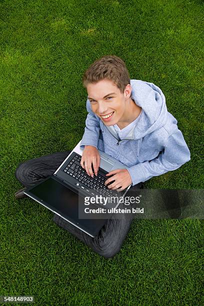 Young man with laptop on a meadow - 2010