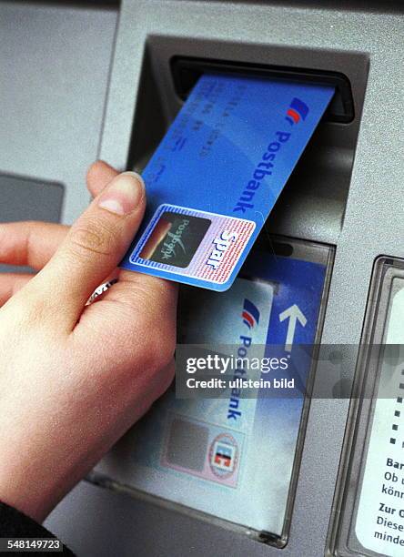 Eine EC-Karte Postbankcard 3000 Plus wird in einen Geldautomaten gesteckt