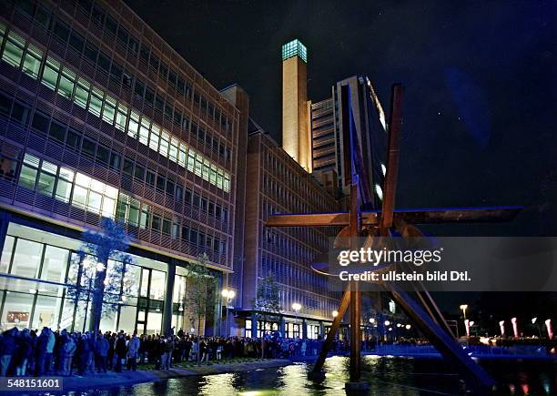 Blick auf den Platz mit der debis-Zentrale; im Vordergrund die Plastik "Galileo" von Mark di Suvero; die Szenerie ist aufgrund einer Lasershow blau...