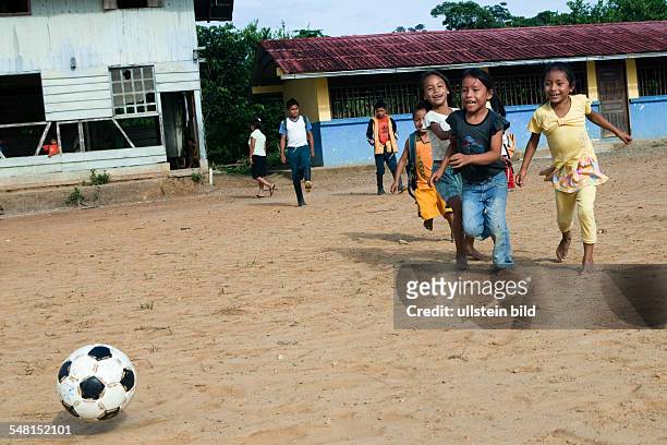 Ecuador Curaray - A village without any road connection in the rainforest of the Oriente, 150 km east of Puyo. Kids playing soccer in the schoolyard...