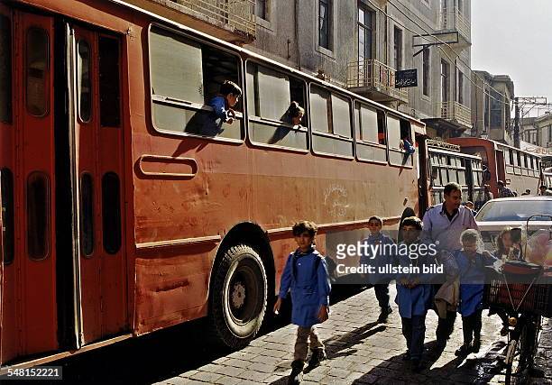 Schüler in Uniform vor und in einem Schulbus in Damaskus - November 1998