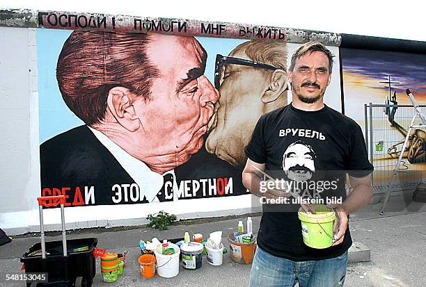 Vrubel, Dimitry - Painter, Artist, Russia - restoring his painting "brotherly kiss" at the East Side Gallery in Berlin