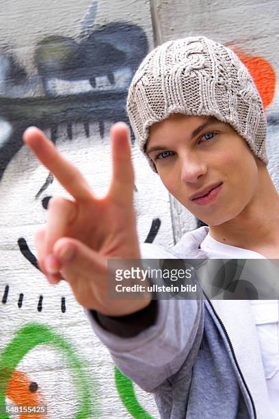 Young man with woolen cap in front of wall with graffity - 2010