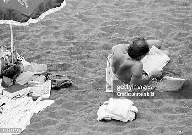 Holidays, tourism, man lies on the beach and reads a newspaper, Spain, Canary Islands, Canaries, Tenerife, Puerto de la Cruz -