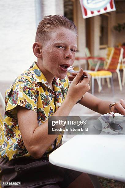 Germany - red-haired boy is eating ice cream in a pavement cafe