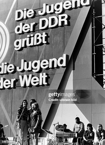 Weltjugendfestspiele / Weltfestspiele der Jugend und Studenten in Berlin / DDR vom 28.07. - : Musikgruppe vor einer Plakatwand 'Jugend der DDR grüsst...