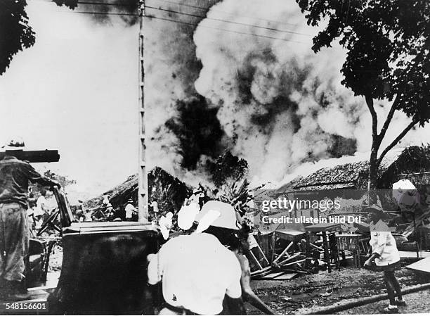 War zone South Vietnam: French and Vietnamese fire brigade in Bien Hoa north of Saigon trying to blow out the fire of two huge oil tanks by Shell...