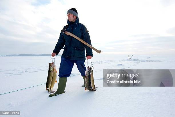 Germany Mecklenburg-Western Pomerania Ruegen - ice fishing at the baltic sea, fisherman is fishing pikes
