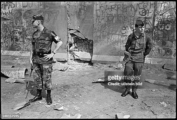 Germany, Berlin, , Bomb attack on the Berlin wall at Zimmerstrasse in the district of Kreuzberg. GDR border soldier and member of US Army Military...