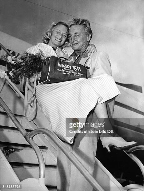 Stauffer, Teddy *-+ Musiker, Bandleader, Schweiz - traegt seine Frau Ute Weller die Gangway eines Flugzeuges hinunter - 1957