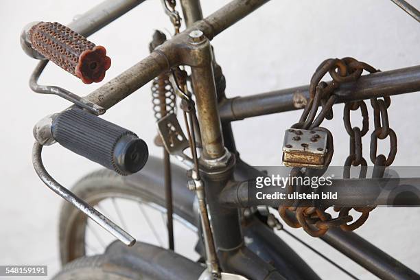 Rusty bicycles linked with a chain