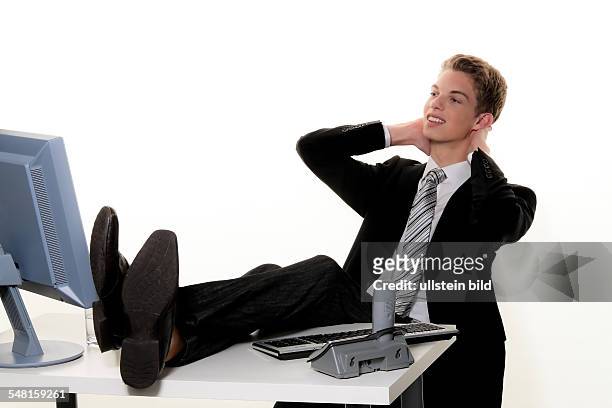 Young man with computer in an office with his legs on the desk - 2010