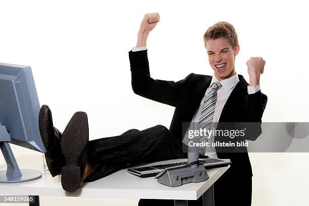 Young man with computer in an office with his legs on the desk - 2010