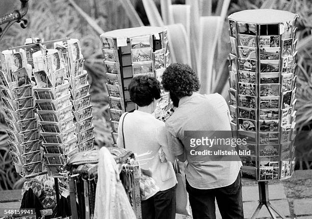 People, young couple chooses picture postcards in mapstands, holidays, Spain, Canary Islands, Canaries, Tenerife, aged 25 to 35 years -