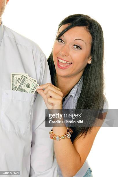 Young woman is pulling cash out of the pocket of a man -