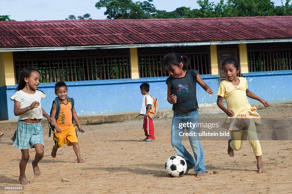 Ecuador Curaray - A village without any road connection in the rainforest of the Oriente, 150 km east of Puyo. Kids playing soccer in the schoolyard before lessons start