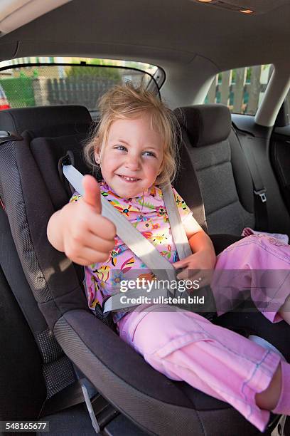 Girl is sitting on a child car seat -