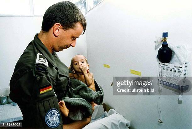 Peacekeeping Missions of the German Armed Forces A German soldier is taking care of a malnourished child in Cambodia, as part of Germany's UNTAC...