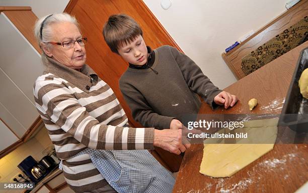Grand mother and grandson are baking Chritmas cookies -