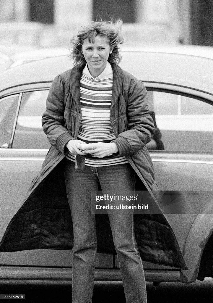 People, young woman stands stands in front of a car, pulli, cloak, jeans trousers, aged 30 to 35 years, Kriemhild - 15.12.1980