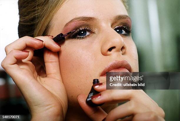 Junge Frau schminkt sich mit einem Eyeliner die Augenlider - 2000