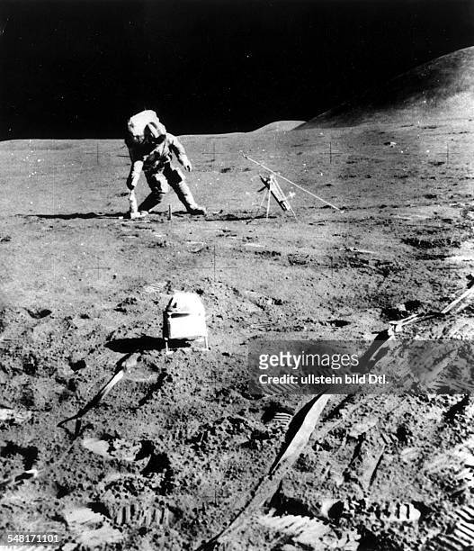 Astronaut David Scott bei der geologischen Feldarbeit auf der Mondoberfläche; im Vordergrund das Sonnenwind-Messgerät des ALSEP - 1971