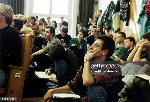 Studenten sitzen während einer Vorlesung an der Humboldt-Universität im überfüllten Hörsaal auf dem Boden - Oktober 1995 Werbliche Nutzung und...