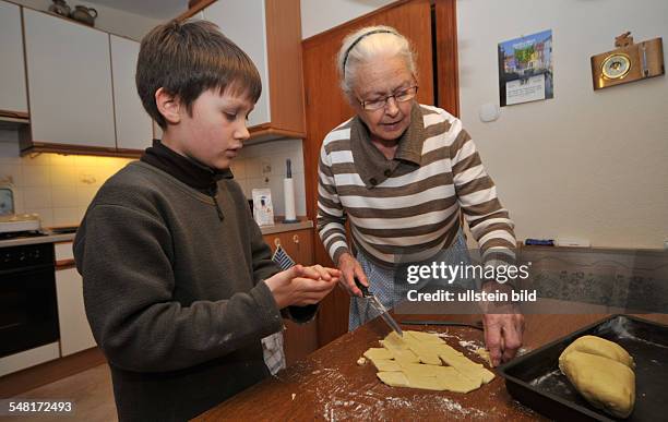 Grand mother and grandson are baking Chritmas cookies -