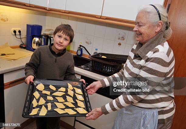 Grand mother and grandson are baking Chritmas cookies -