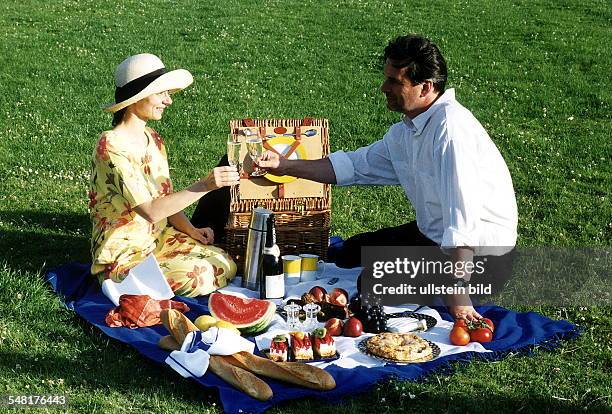 Junges Paar beim Picknick auf einer Wiese trinkt Sekt - Juli 1999