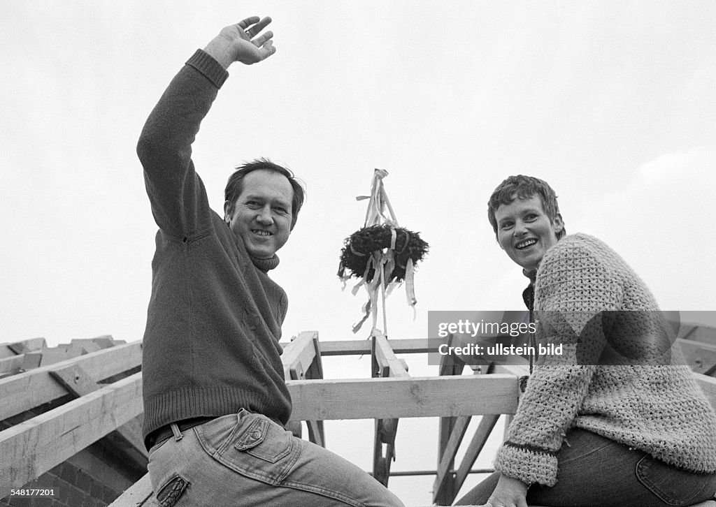 Building site, shell construction, one-family house, topping out ceremony, evergreen tree, building owners pose on the roof truss, woman, aged 30 to 35 years, man, aged 35 to 40 years, Sigrun, Helmut - 21.04.1978