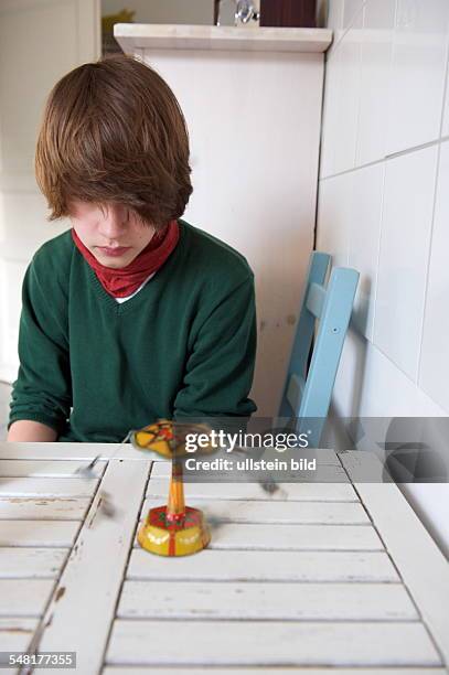 Boy with toy roundabout on the kitchen table -