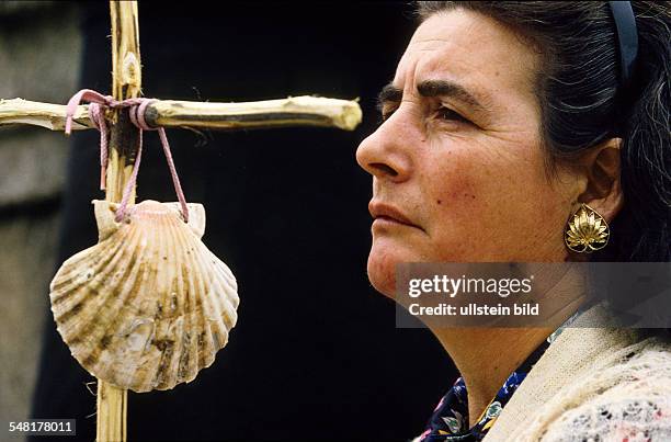 Spain - female pilgrim with Jacob-mussels at her staff at the destination of the pilgrims way -