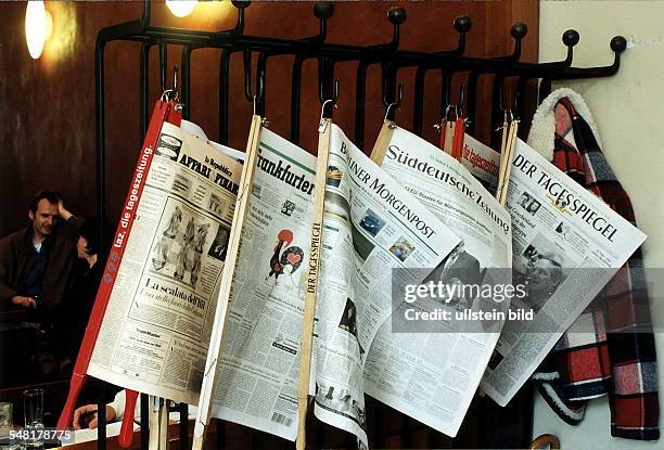 Verschiedene Tageszeitungen hängen in einem Cafe