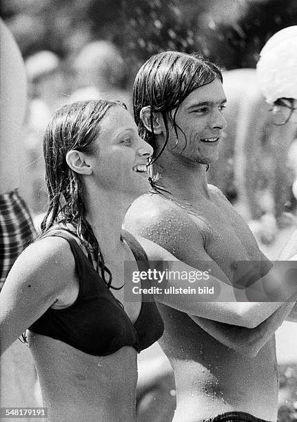 People, young couple in an open-air swimming pool, bikini, bathing trunks, fun, aged 18 to 25 years -