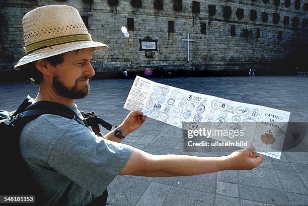 Spain - pilgrim shows his stamped Certificate in Santiago de Compostella -