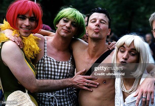 Teilnehmer der Homosexuellen - Parade mit bunten Perücken umarmen sich und posieren mit Kussmund