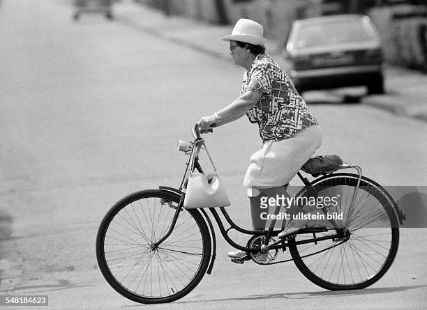 People, older woman drives a bicycle, aged 50 to 60 years -