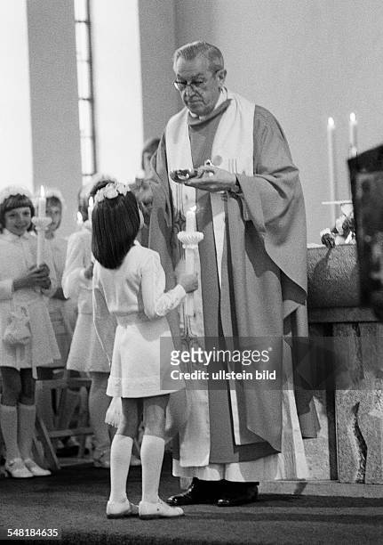 Religion, Christianity, First Communion, Eucharistic mass, priest administers the Holy Communion to a girl, aged 8 to 12 years, aged 60 to 70 years,...