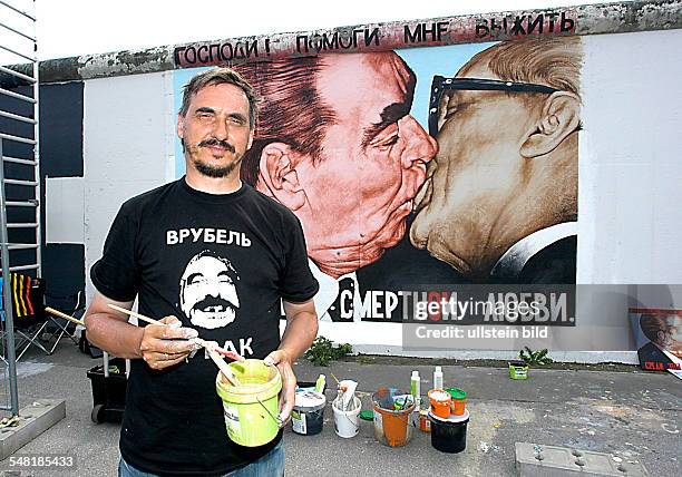 Vrubel, Dimitry - Painter, Artist, Russia - restoring his painting "brotherly kiss" at the East Side Gallery in Berlin