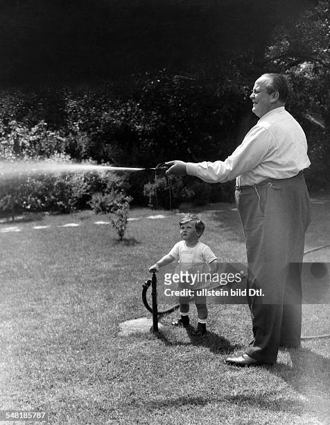 Actor, Germany *21.02.1889-+. German actor Otto Wallburg watering the lawn of his garden together with his son, Peter Klaus, 1933. Photographer:...