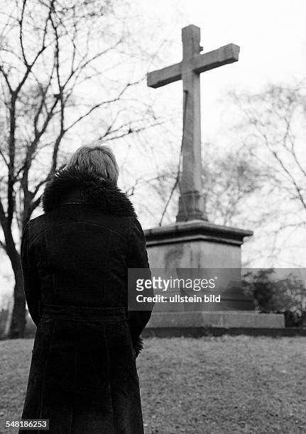 People, death, mourning, churchyard, young woman stands in front of a memorial cross, aged 25 to 30 years, Monika -