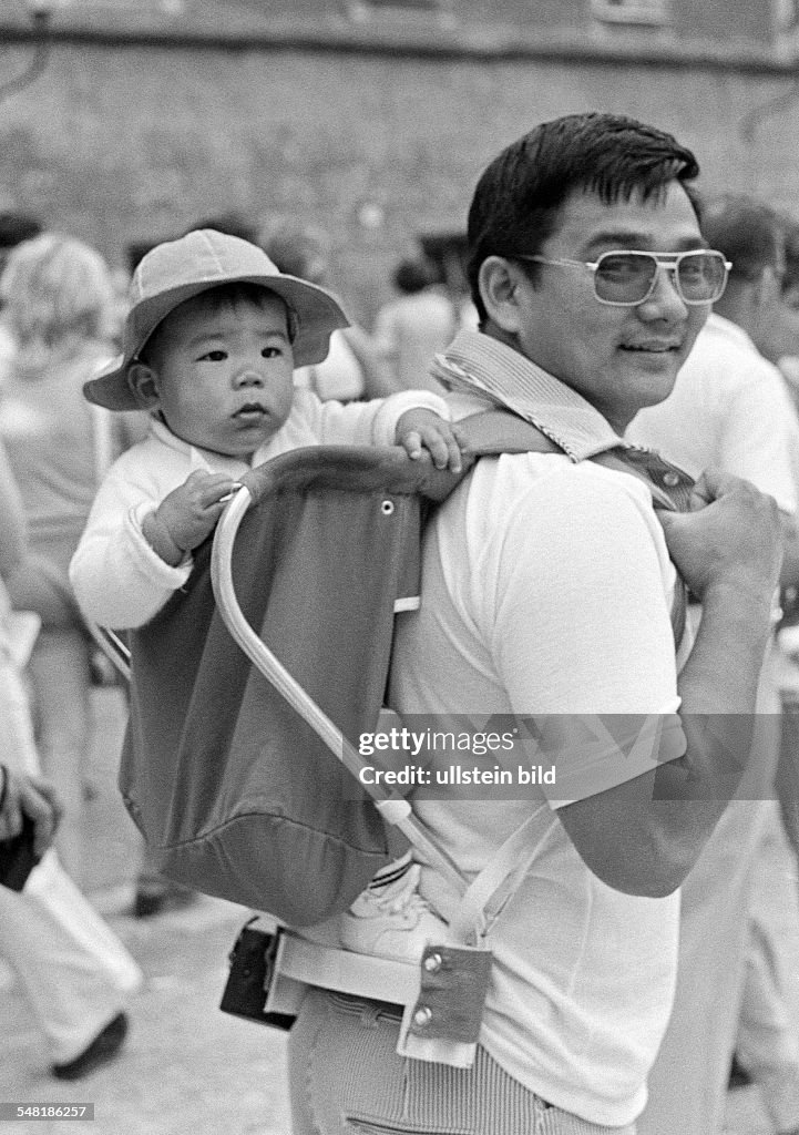 People, young father carries the little son on his back in a knapsack, Japanese, tourists, aged 25 to 35 years, aged 1 to 2 years, Austria, Salzburg - 15.08.1974