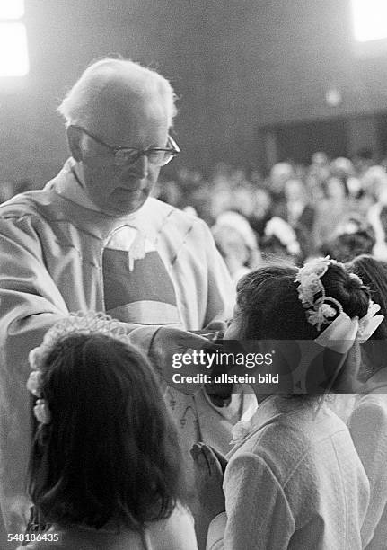 Religion, Christianity, First Communion, Eucharistic mass, priest administers the Holy Communion to a girl, aged 8 to 12 years, aged 55 to 65 years,...