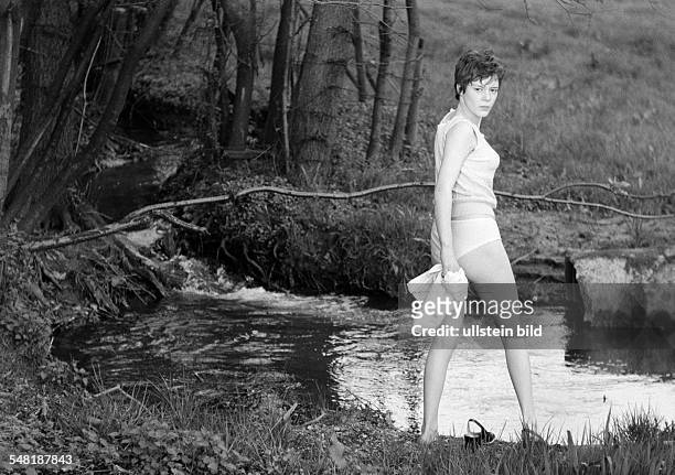 People, young girl dressed only in a top and panties goes for bathing to a brook, aged 18 to 22 years -