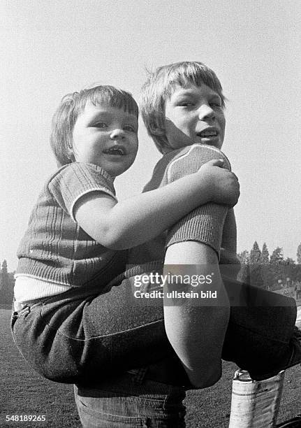 People, children, boy bears a younger boy piggyback, aged 10 to 13 years, aged 6 to 8 years -