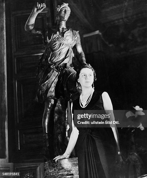 Princess Altieri standing in front of a statue in a black evening dress with pearl necklace - 1937 - Photographer: Regine Relang - Published by: 'Die...