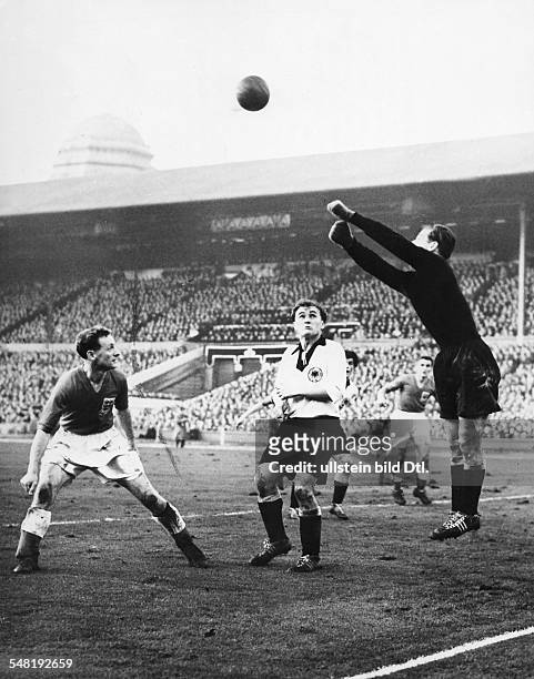 Im Wembley-Stadion von London - Der deutsche Torwart Fritz Herkenrath faustet den Ball vor Tom Finney weg, während Jupp Posipal zuschaut