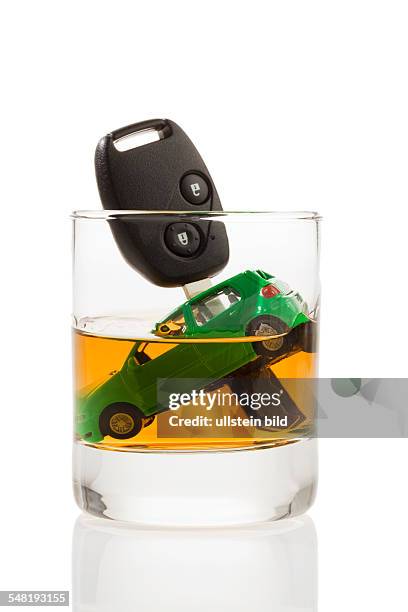 Car key and model of a car in a glass with alcohol